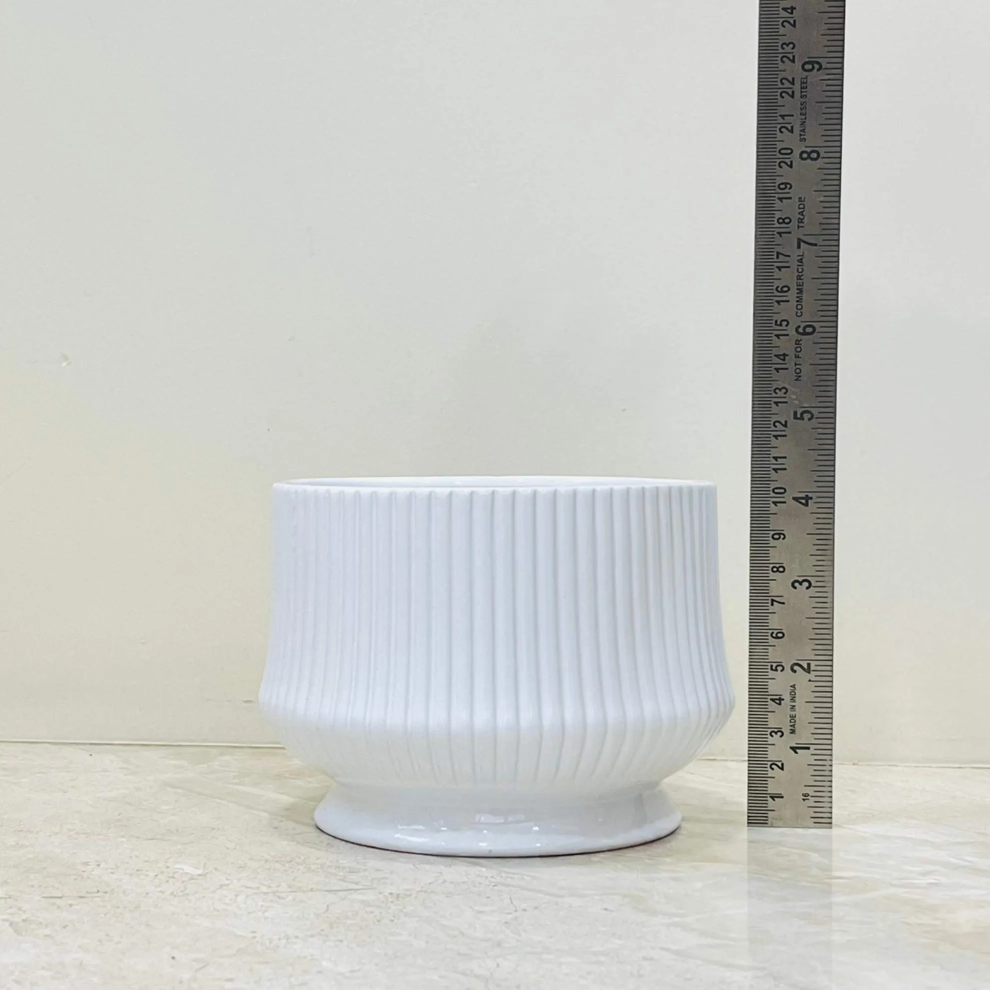 Glossy white ceramic pot with ribbed design