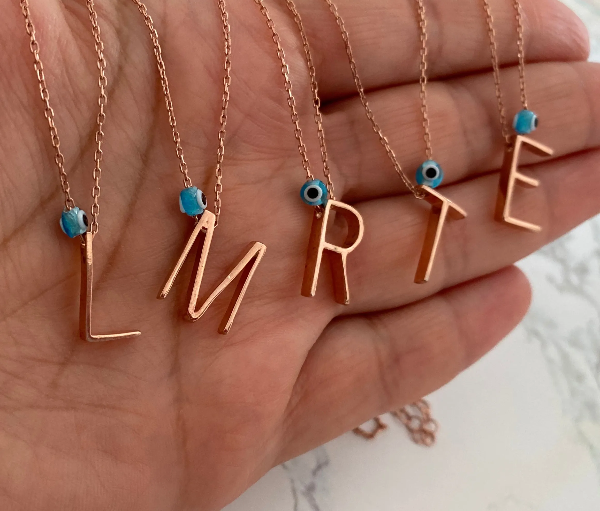 Minimalist letters with evil eye charm